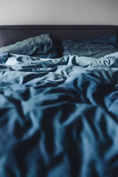 depositphotos_450594884-stock-photo-messy-queen-size-bed-blue