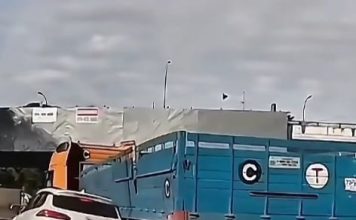 白色轿车贴近罗里转弯 结果被推上安全岛卡死