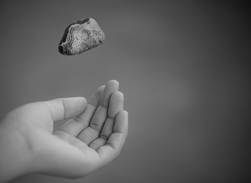Young woman hand throwing stone
