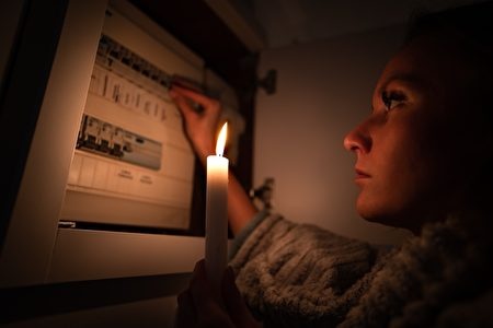 Woman,Checking,Fuse,Box,At,Home,During,Power,Outage,Or