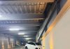 白色轿车冲破停车场墙壁 碎石坠落砸中下方3车