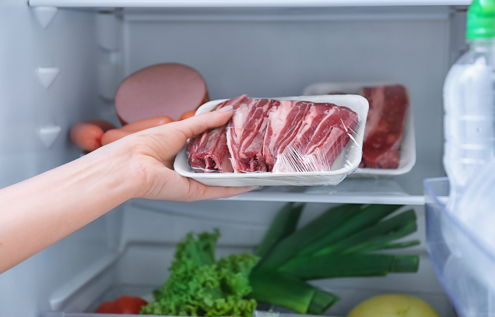 Woman,Putting,Raw,Meat,In,Refrigerator,,Closeup
