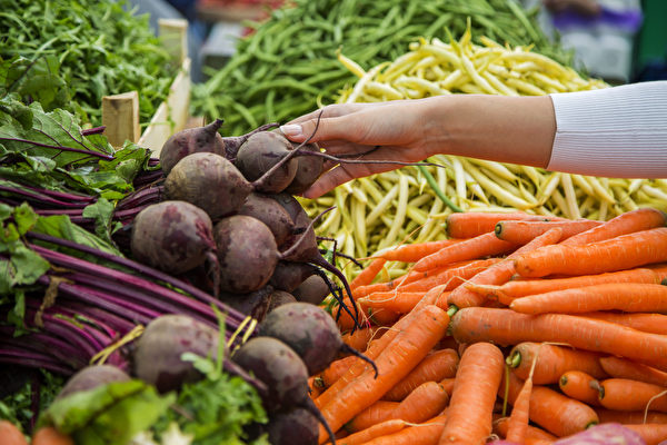 Woman,Buying,Vegetables,On,The,Market