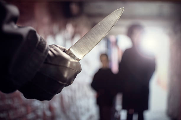 Criminal with knife weapon threatening woman and child in underpass crime